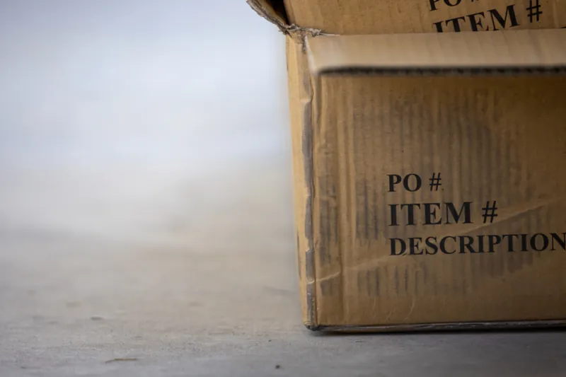 Caja de cartón lista para despachar, apoyada en el piso
